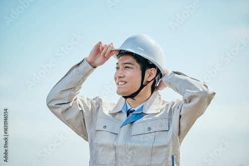 Foto ヘルメットをかぶる作業服姿の男性