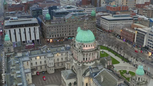 Aerial drone footage of Belfast City Hall during a peaceful evening, capturing gentle city activity.