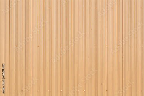 Beige corrugated metal siding texture background. Wall panel with vertical lines creating an industrial abstract pattern.