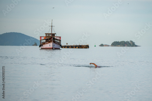 Nadador solitário nadando no mar aberto na praia do anil em Angra dos Reis no Rio de Janeiro, Brasil.