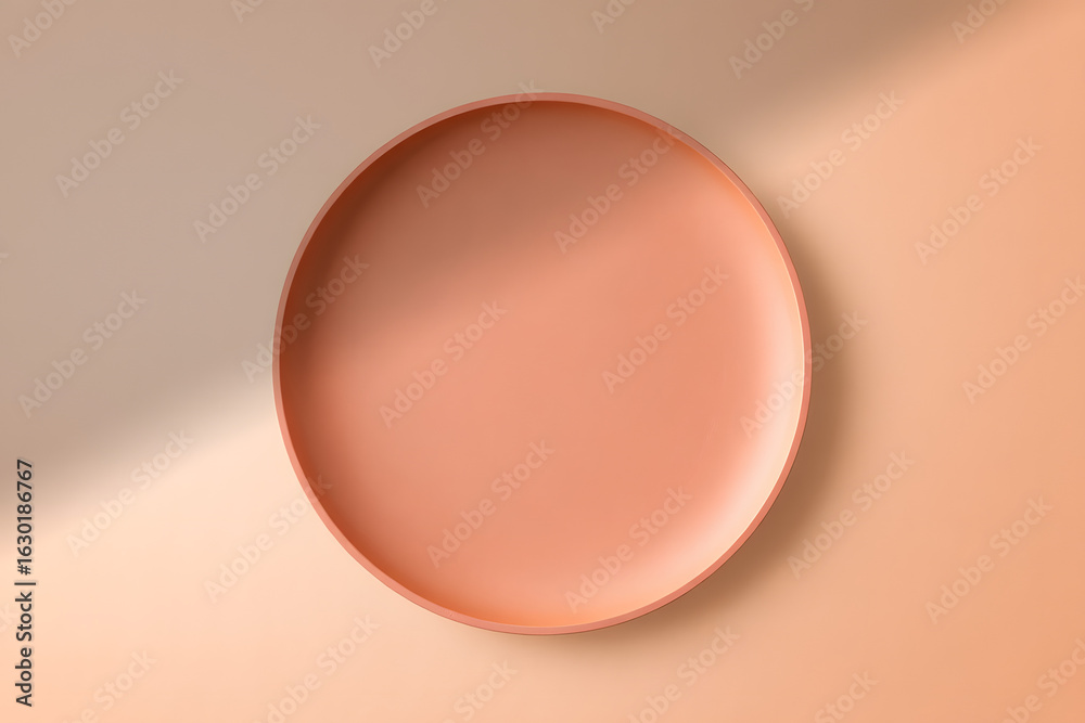 Fototapeta premium Minimalist top-down view of an empty ceramic plate on a pastel beige and peach background with a soft shadow. Ideal for product mockups.