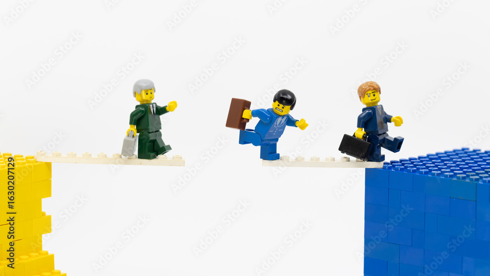 Naklejka premium Hong Kong - August 4 2025: a group of office boy take a challenge that walk on a tightrope