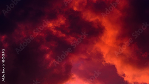 Fototapeta Naklejka Na Ścianę i Meble -  red cloudy mystical sky. artistic photo of clouds illuminated by setting sun. background dramatic sunset cloudscape. horizontal side view in 16x9 format