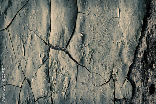 Peeling paint on the wall. Panorama of a concrete wall with old cracked flaking paint. Weathered rough painted surface with patterns of cracks and peeling. Wide panoramic texture for design background