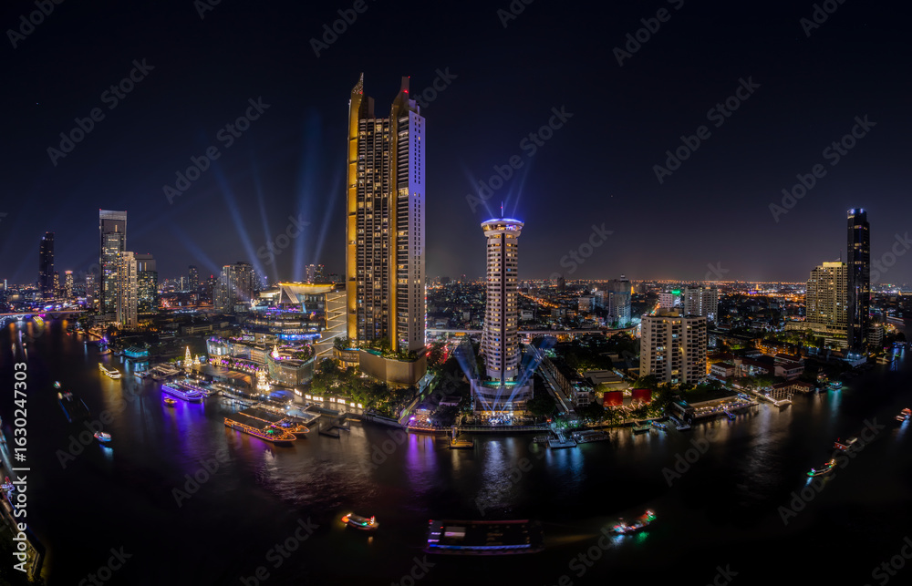 Naklejka premium Modern buildings in the city with water reflection, firework, light show at night time.