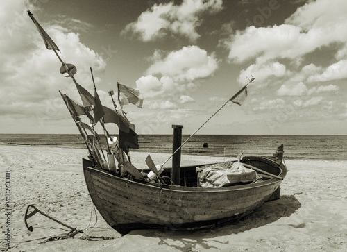 Fototapeta Naklejka Na Ścianę i Meble -  the small fishing boat on the Baltic Sea beach at sunset