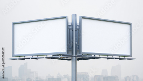 Two blank billboards mounted on a central pole against a hazy city skyline