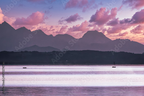 Impressive view over Lake Chiemsee with a view of the Alps at sunset and approaching clouds