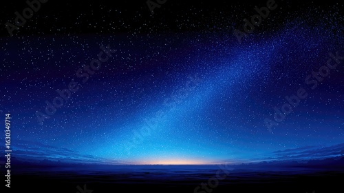 Fototapeta Naklejka Na Ścianę i Meble -  Starry night sky over a dark horizon.  Vast expanse of a deep blue night sky dotted with numerous stars.  A band of pale light, resembling dawn or dusk, touches the horizon