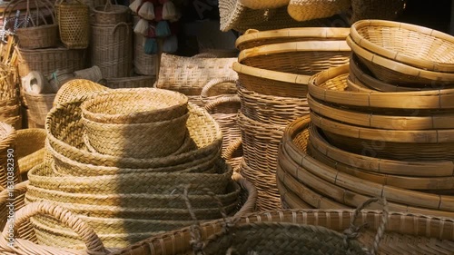 Collection of handmade wicker baskets, trays, hats and weaving bags displayed at traditional market in Chiang Mai, Thailand. Store with handmade goods, traditional craftsmanship, sustainability