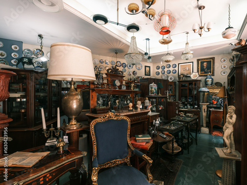 Cluttered and atmospheric view of an antique store with old books, art, and furniture.
