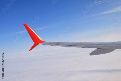 Airplane wing on blue sky background