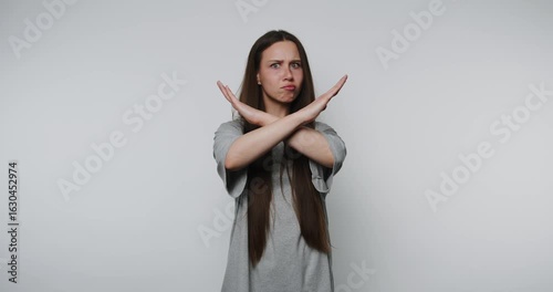 concerned woman crosses her arms in refusal gesture on white background
