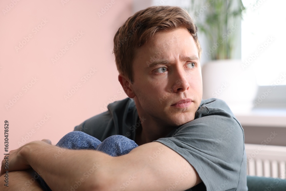 Scared man suffering from paranoia at home Scared man suffering from paranoia at home