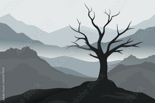 Silhouette of a bare tree against a misty mountain landscape