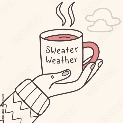 Cozy Mug: A gentle hand cradles a whimsical mug filled with a comforting warm beverage. Its adorned with the words Sweater Weather beckons a feeling of home and comfort. 