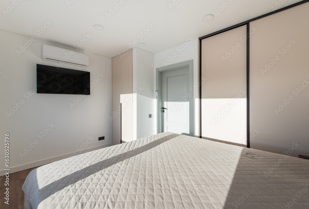 Obraz premium Bedroom Interior. Beautiful Sunlight. King Size Bed and Windows. TV Screen and AC on the Wall.