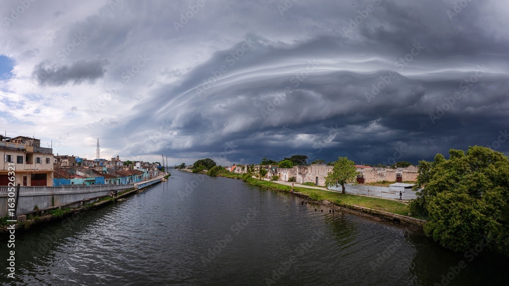 Fototapeta premium Dramatic storm clouds over a city river.