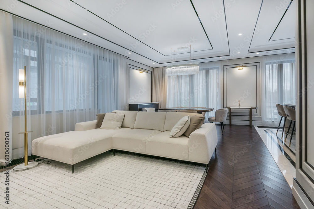 Naklejka premium Modern interior design of the living room with elegant furniture and large windows filling the space with soft natural light.