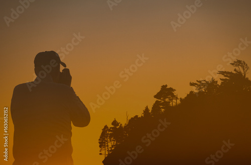 silhouette of a man taking a photo