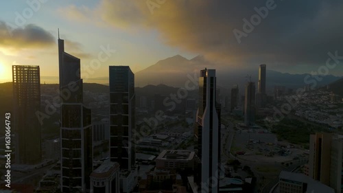June 24, 2025. Monterrey, Mexico: a beautiful sunrise in the corporate district illuminates the sky with warm tones. The sun rises between the buildings. In the background, the Cerro de la Silla hill.
