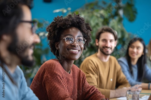 A cheerful group of diverse friends enjoying a lively conversation during a team meeting filled with laughter and collaboration