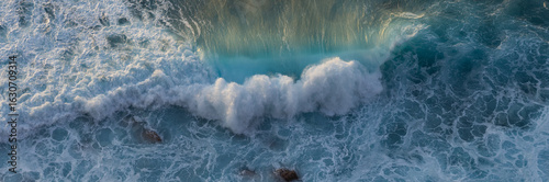 Blue ocean wave on yellow sandy beach. Sea waves and sand the summer background. Summer seascape beautiful waves, blue sea water. Top view from drone. Sea aerial view, tropical nature background.