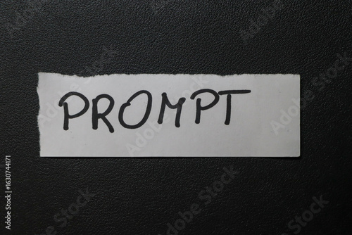 Handwritten word PROMPT on a white paper sheet against a dark background. Ideal for themes of creativity, communication, and inspiration in various projects.