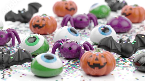 A hyper-realistic shot of Halloween-themed candies with falling glitter, perfect for festive promotions or holiday content.