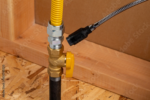 Checking natural gas or propane fitting with leak detector. Plumbing, home maintenance, natural gas safety and repair concept.