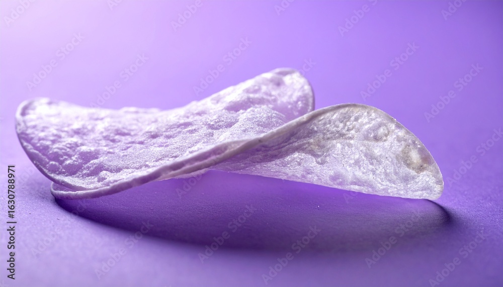 Obraz premium マットクールラベンダーの背景に薄く透けるチップスが並び、柔らかなバックライトでほのかに光る幻想的な食品イメージ