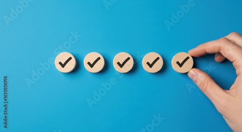 Hand placing last checkmark in a sequence of five, completing a task or checklist