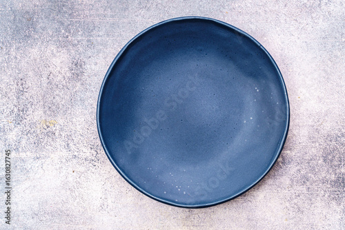 Empty blue plate on concrete