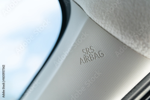 The SRS Airbag label on the interior trim of a car, specifically on the A-pillar. This airbag is part of the car's safety system designed to deploy during a collision to protect the occupants.