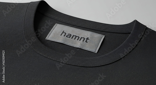 Black t-shirt collar with a blank grey label tag for branding. Apparel mockup for clothing design presentation.