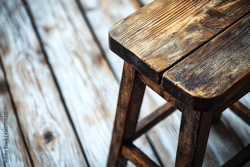 Close-up of weathered wooden stool on light-colored wooden floor