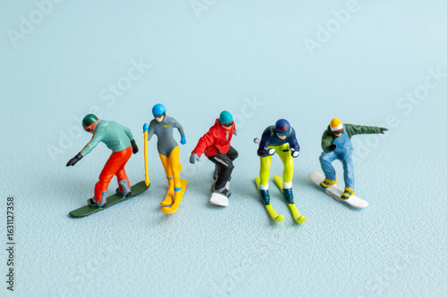 Fotografie Colorful miniature figurines of skiers and snowboarders posed in a dynamic winte