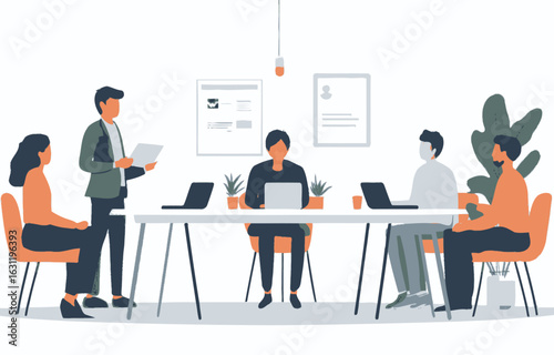 A group of people are sitting around a table with a man standing in front of them. The man is giving a presentation, and the group of people are listening intently. The room is decorated with plants