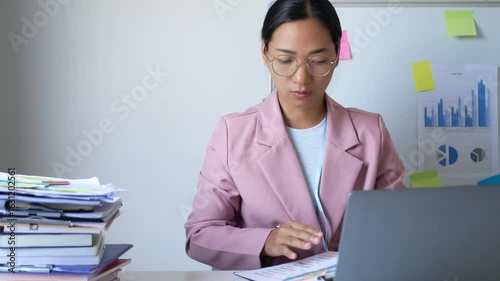 A young female office worker is stressed out by the assigned work. She has not completed her work according to the goals, which makes her irritable and in a bad mood.