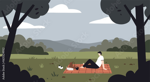Man relaxes on blanket, picnic on meadow, overcast sky, mountains in background