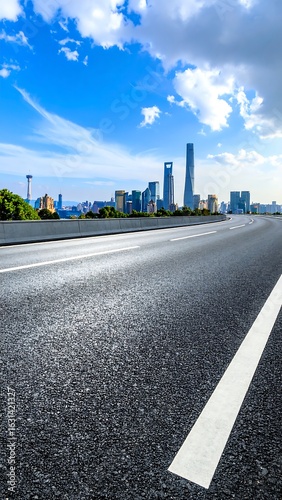 Asphalt road leading to city skyline