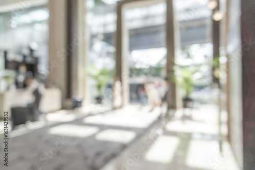 Hotel or office building lobby blur background interior view toward reception hall, modern luxury white room space with blurry corridor and building glass wall window