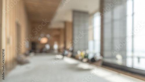 Blurred hotel or office building lobby blur background interior view toward reception hall, modern luxury white room space with blurry corridor and building glass wall window
