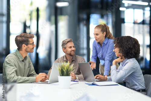 Foto Happy four business people executive team working at laptop having discussion at