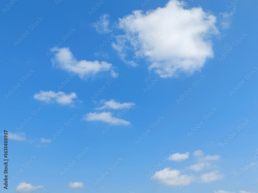 Fototapeta premium Blue sky background with white clouds in summer. Soft white clouds float in the clear blue sky. Clear blue sky, bright spring, soft sky gradient, wallpaper landscape, aerial view.