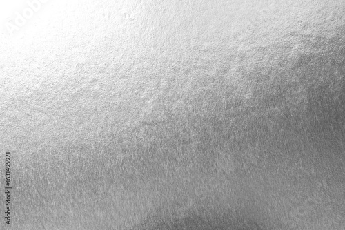Silver background foil leaf metallic texture wrapping paper shiny glowing white grey solid reflective gradient color metal pattern backdrop for wallpaper decoration element backdrop