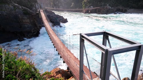 Turbulent waves crash under Tsitsikamma Storms River suspension footbridge