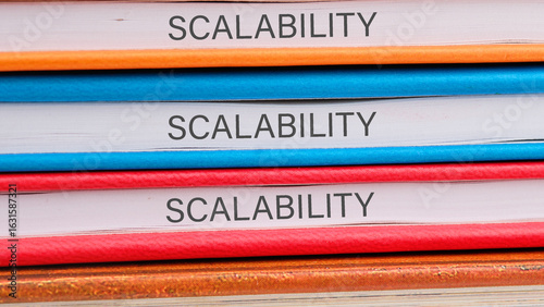 Stacked books displaying the term scalability in bold text highlight the important concept in technology and business, showcasing different colored covers for visual appeal