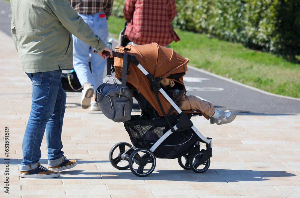 Obraz premium A man is pushing a stroller with a child in it