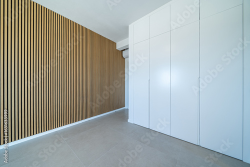 Room with wooden wall texture with wood acoustic panels pattern and closet